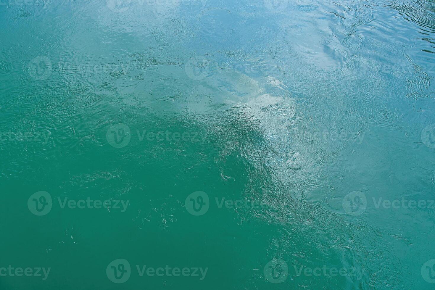 The texture of the waves of turquoise color of fast-flowing water in the river. photo