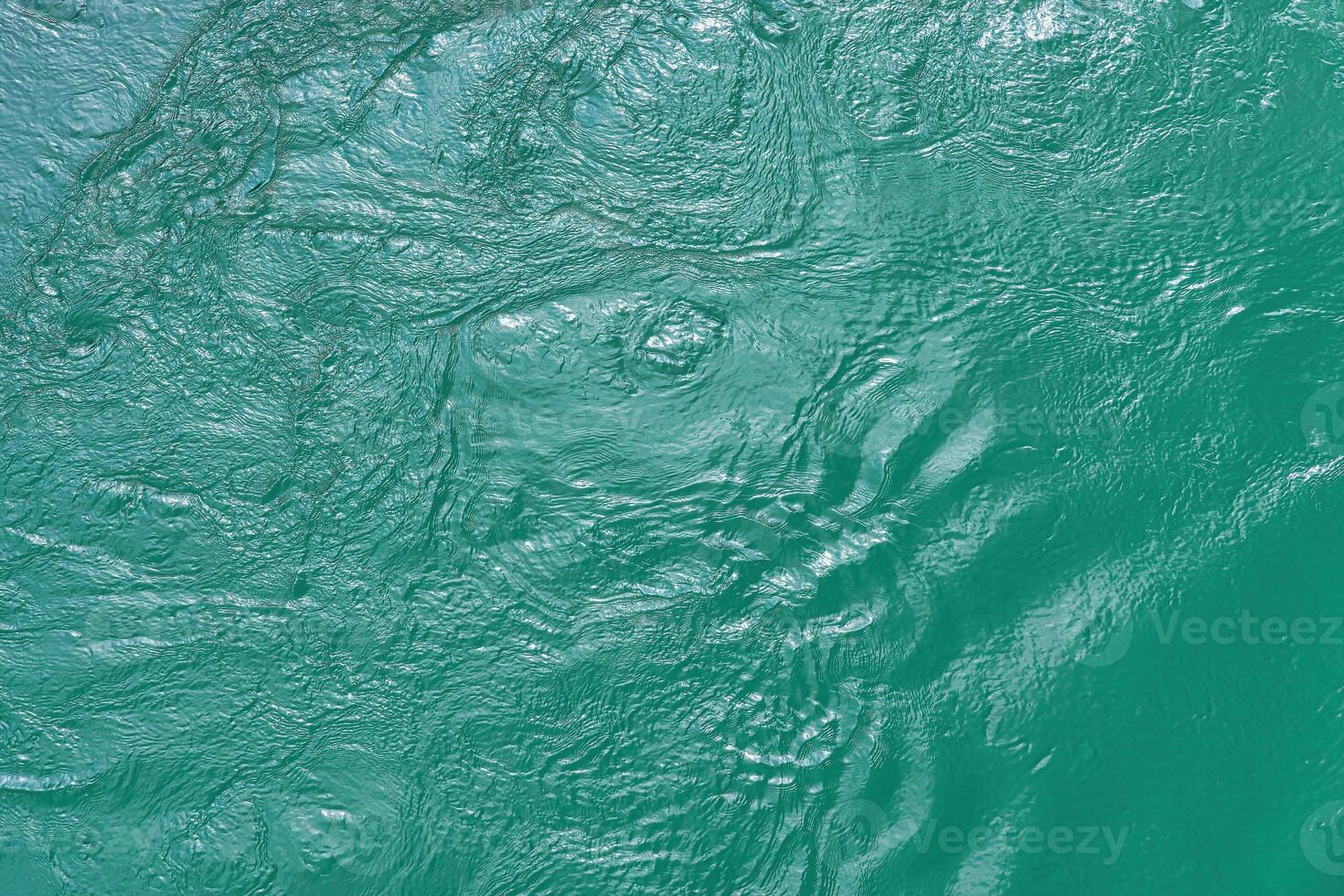 The texture of the waves of turquoise color of fast-flowing water in the river. photo