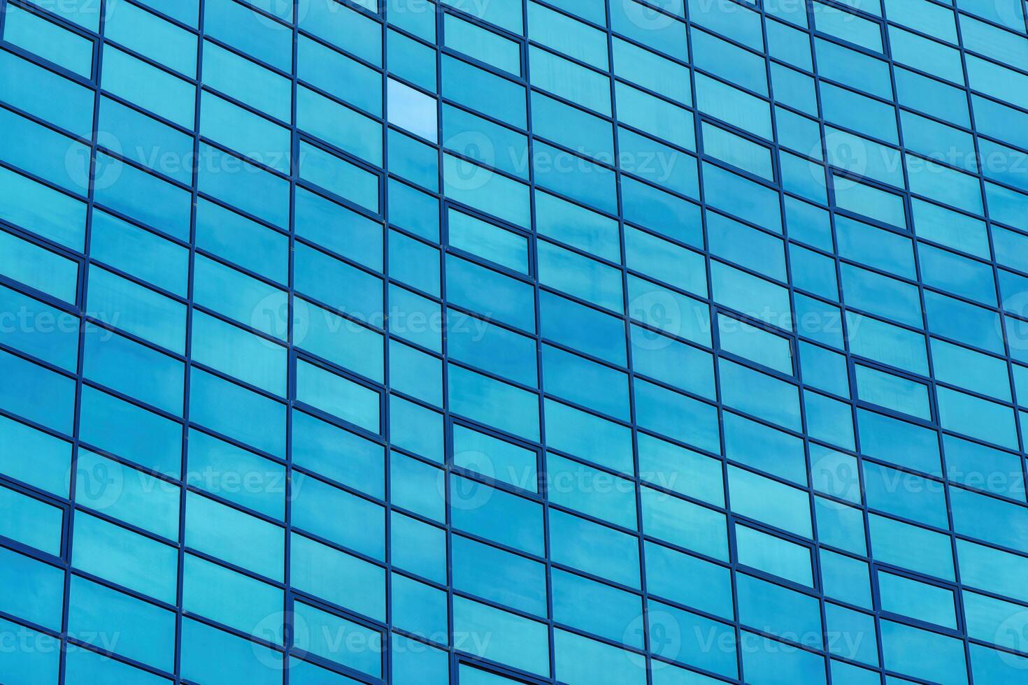 Fragment of a modern office building. Abstract geometric background. Part of the facade of a skyscraper with glass windows. photo