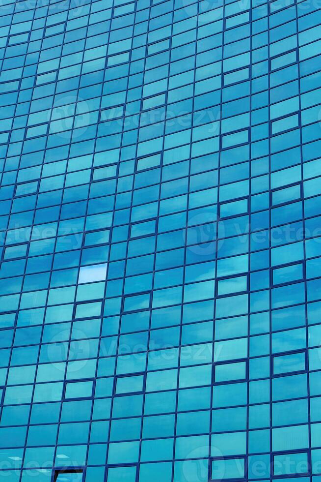 Fragment of a modern office building. Abstract geometric background. Part of the facade of a skyscraper with glass windows. photo