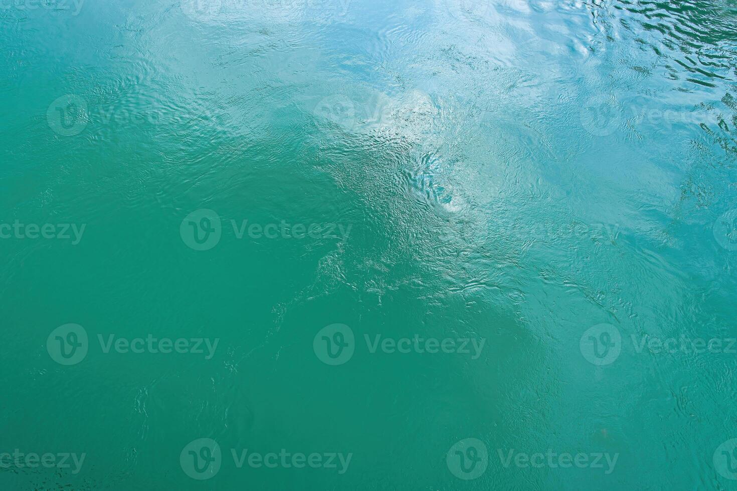 The texture of the waves of turquoise color of fast-flowing water in the river. photo