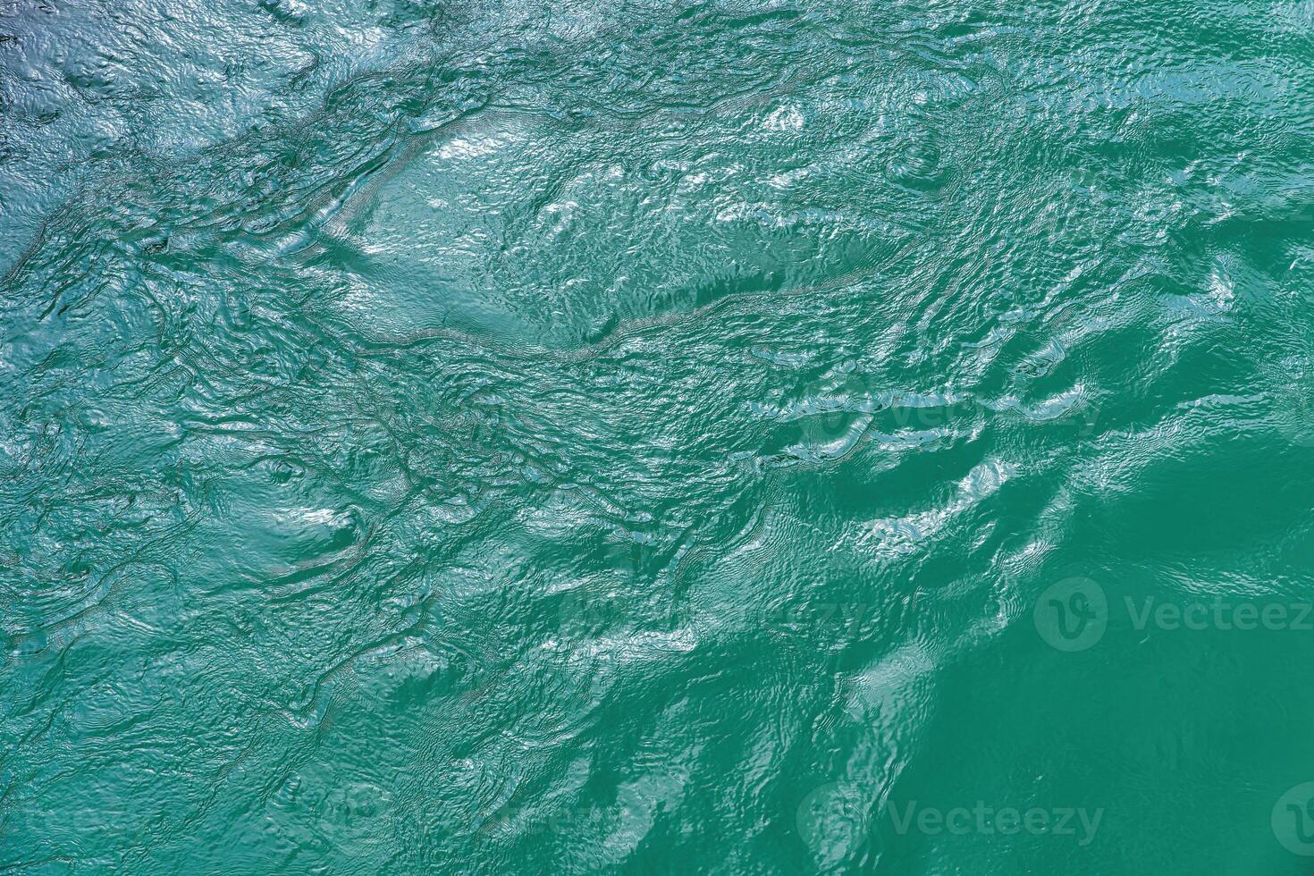 The texture of the waves of turquoise color of fast-flowing water in the river. photo