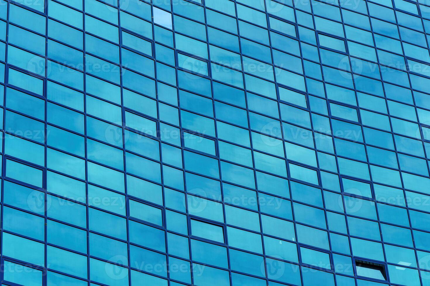 Fragment of a modern office building. Abstract geometric background. Part of the facade of a skyscraper with glass windows. photo