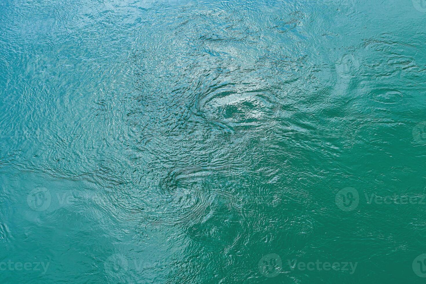 The texture of the waves of turquoise color of fast-flowing water in the river. photo