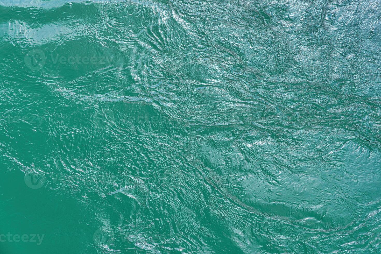 The texture of the waves of turquoise color of fast-flowing water in the river. photo