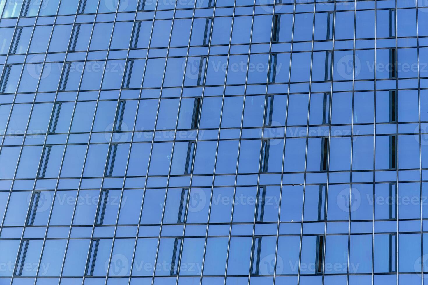 Fragment of a modern office building. Abstract geometric background. Part of the facade of a skyscraper with glass windows. photo