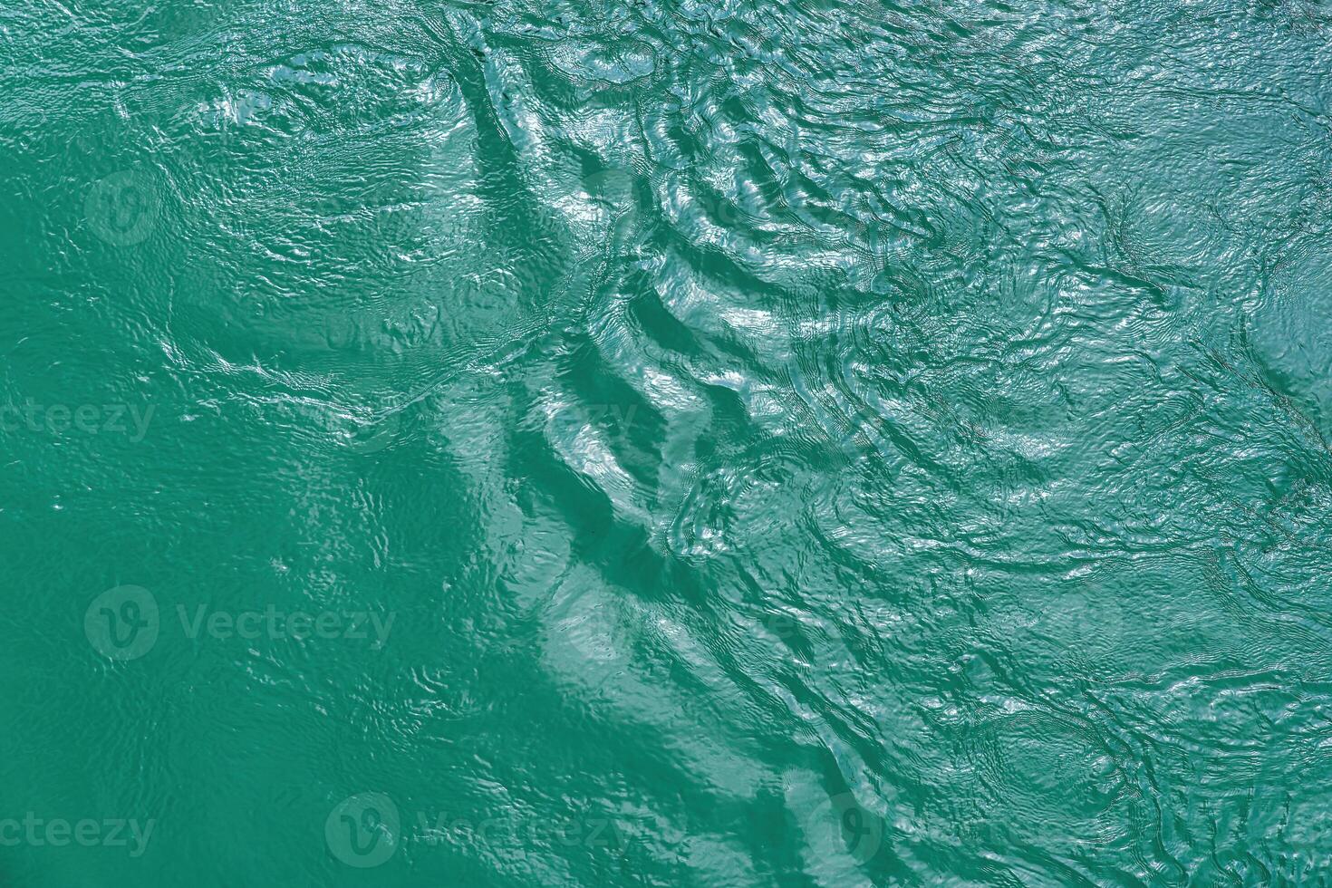 The texture of the waves of turquoise color of fast-flowing water in the river. photo