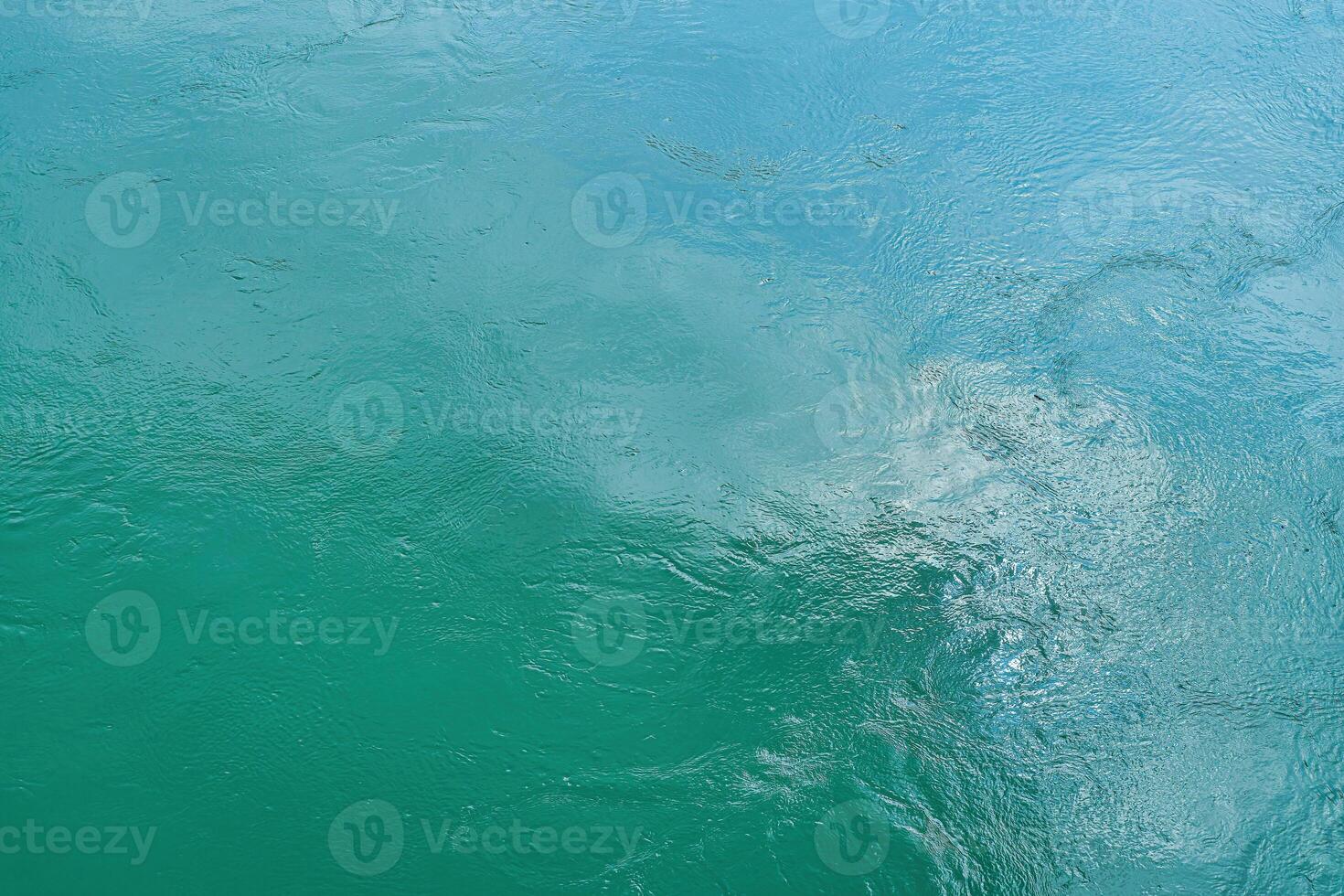 The texture of the waves of turquoise color of fast-flowing water in the river. photo