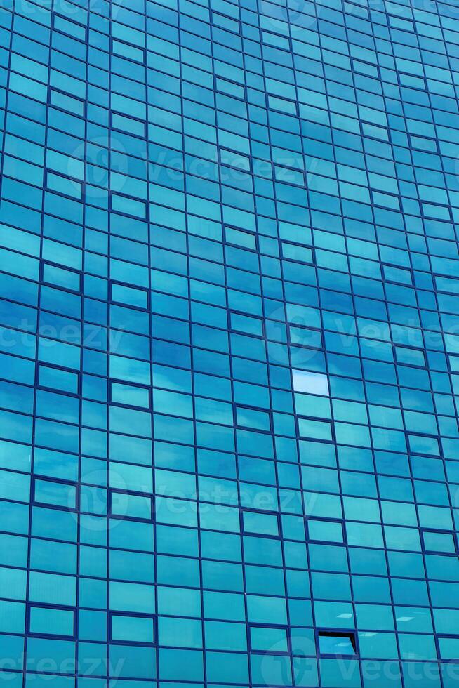 Fragment of a modern office building. Abstract geometric background. Part of the facade of a skyscraper with glass windows. photo