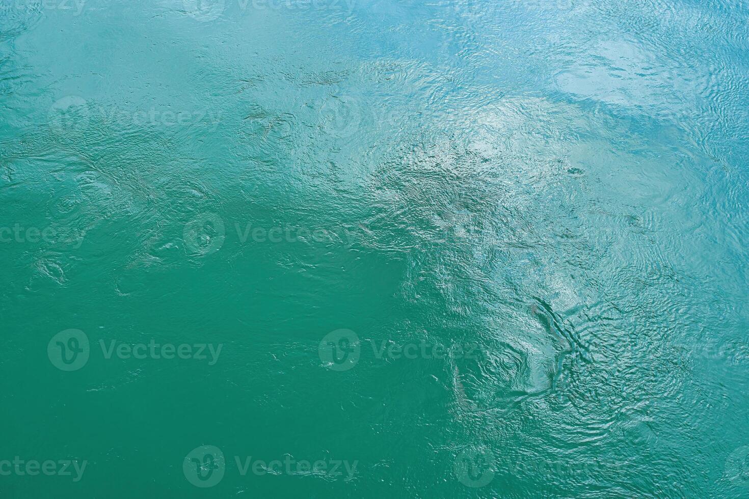 The texture of the waves of turquoise color of fast-flowing water in the river. photo