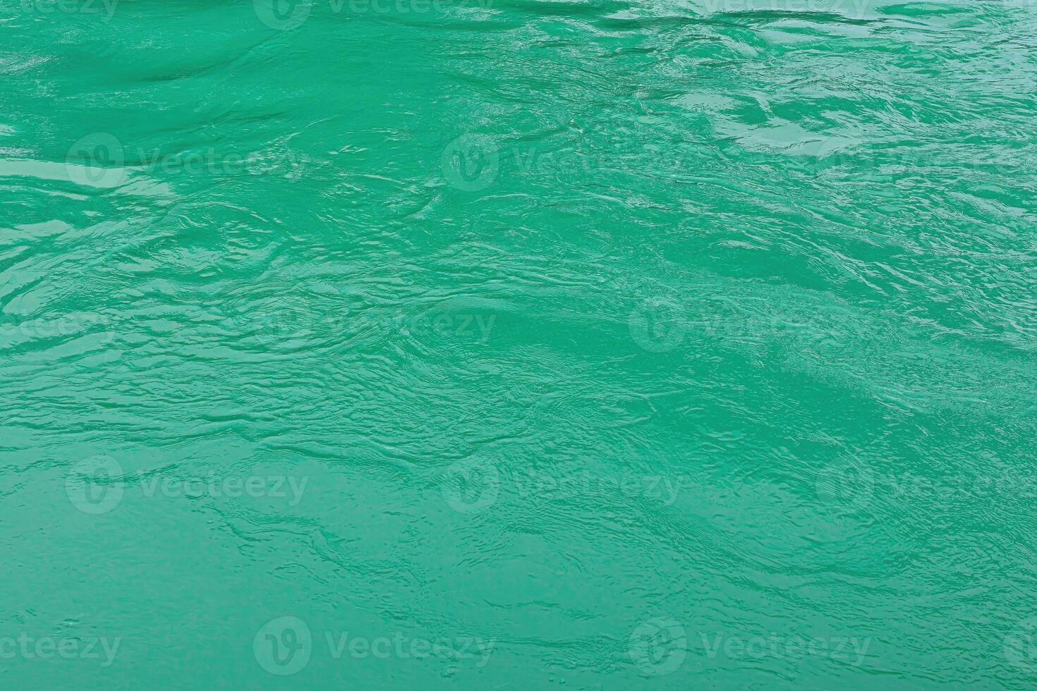 The texture of the waves of turquoise color of fast-flowing water in the river. photo