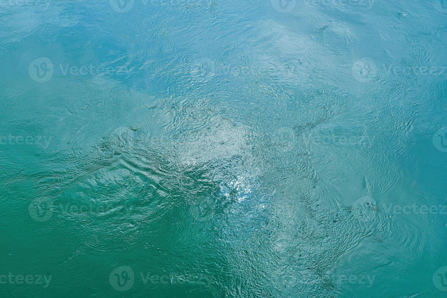 The texture of the waves of turquoise color of fast-flowing water in the river. photo