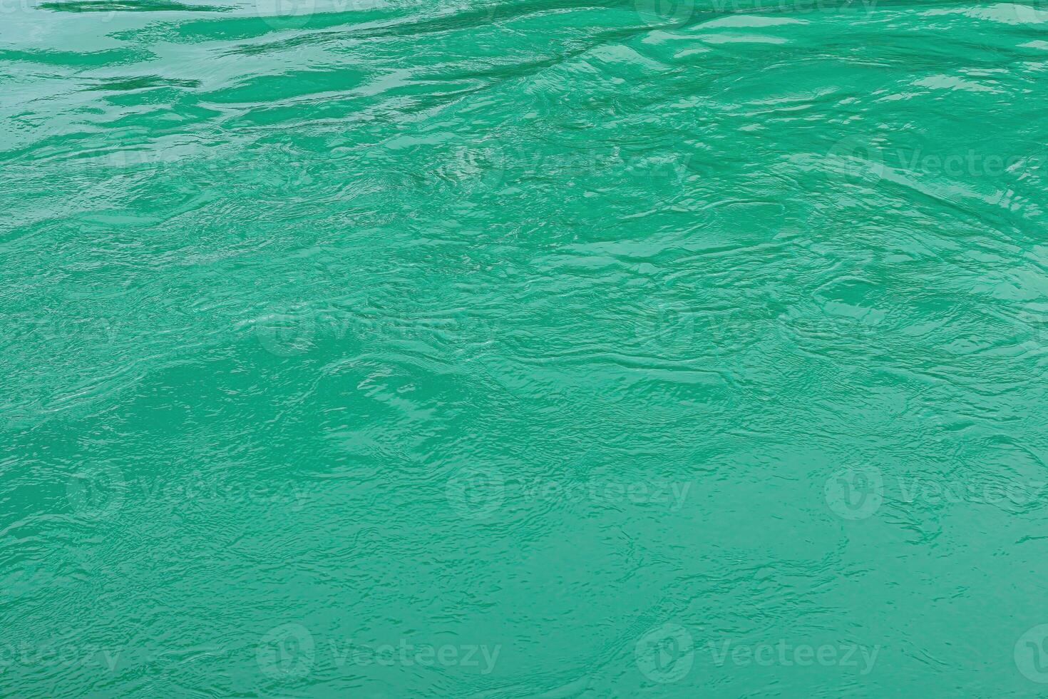 The texture of the waves of turquoise color of fast-flowing water in the river. photo