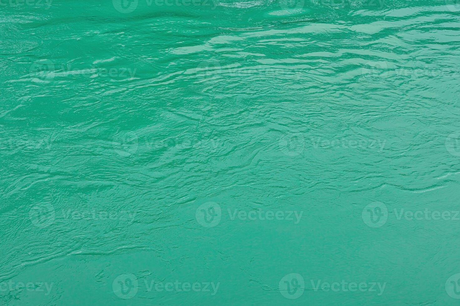 The texture of the waves of turquoise color of fast-flowing water in the river. photo