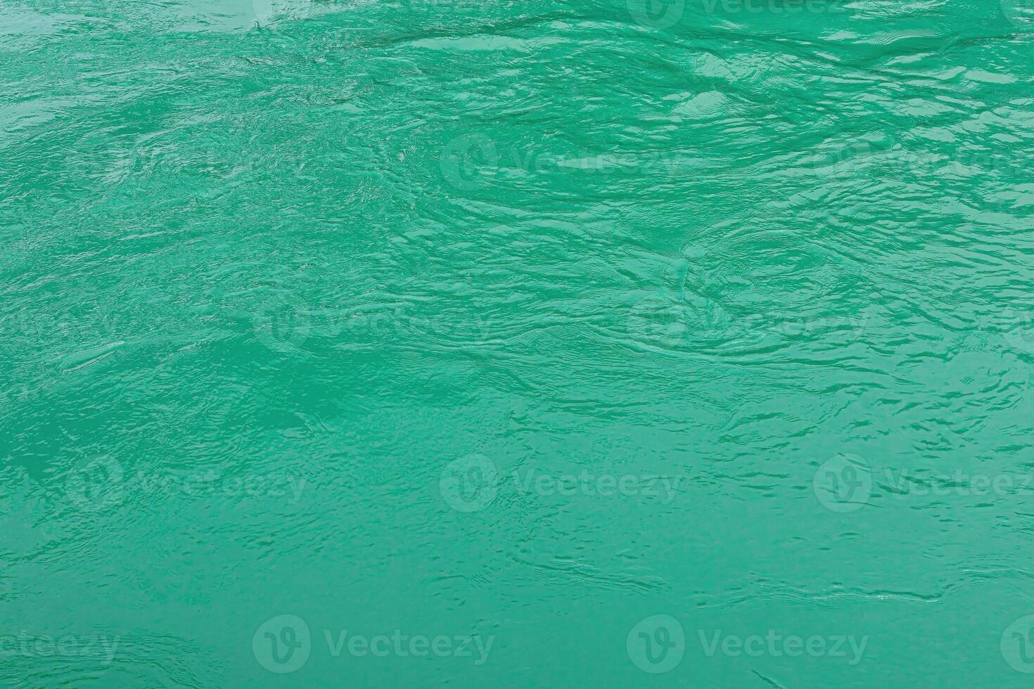 The texture of the waves of turquoise color of fast-flowing water in the river. photo