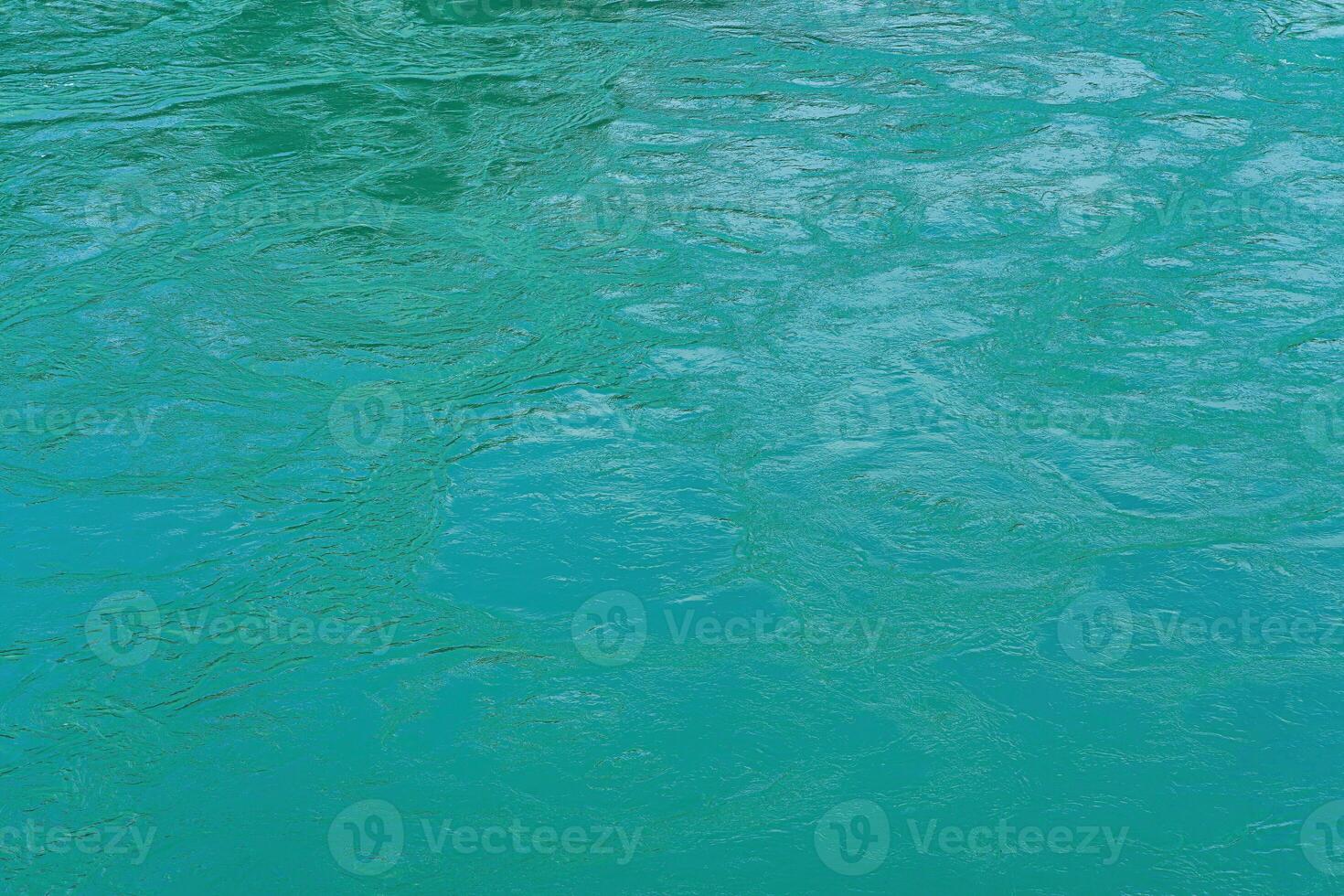 The texture of the waves of turquoise color of fast-flowing water in the river. photo