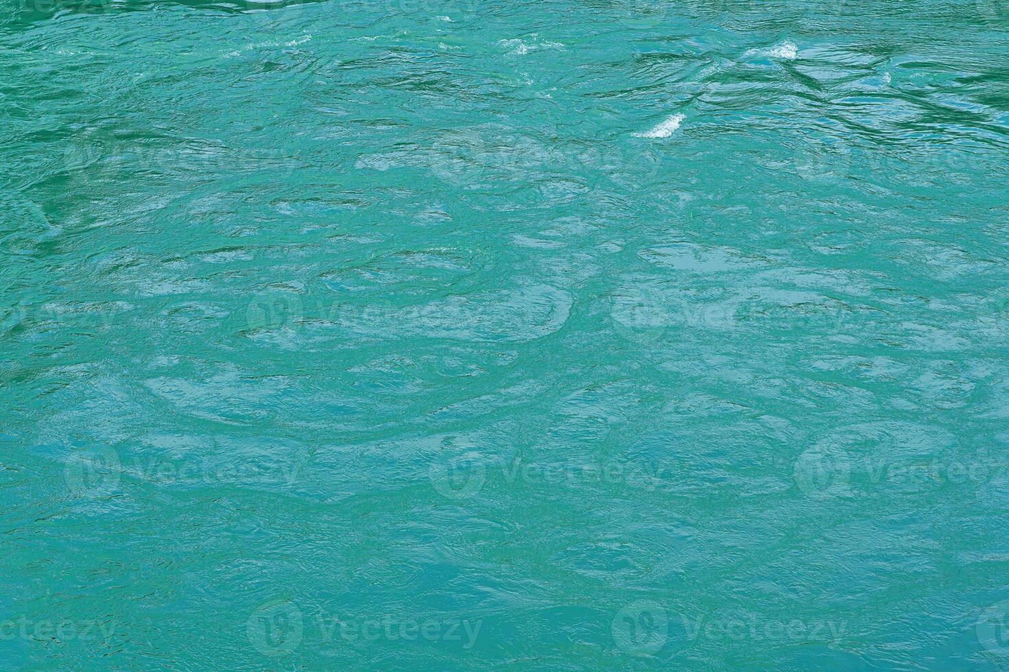 The texture of the waves of turquoise color of fast-flowing water in the river. photo