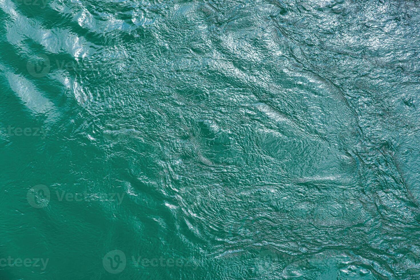 The texture of the waves of turquoise color of fast-flowing water in the river. photo