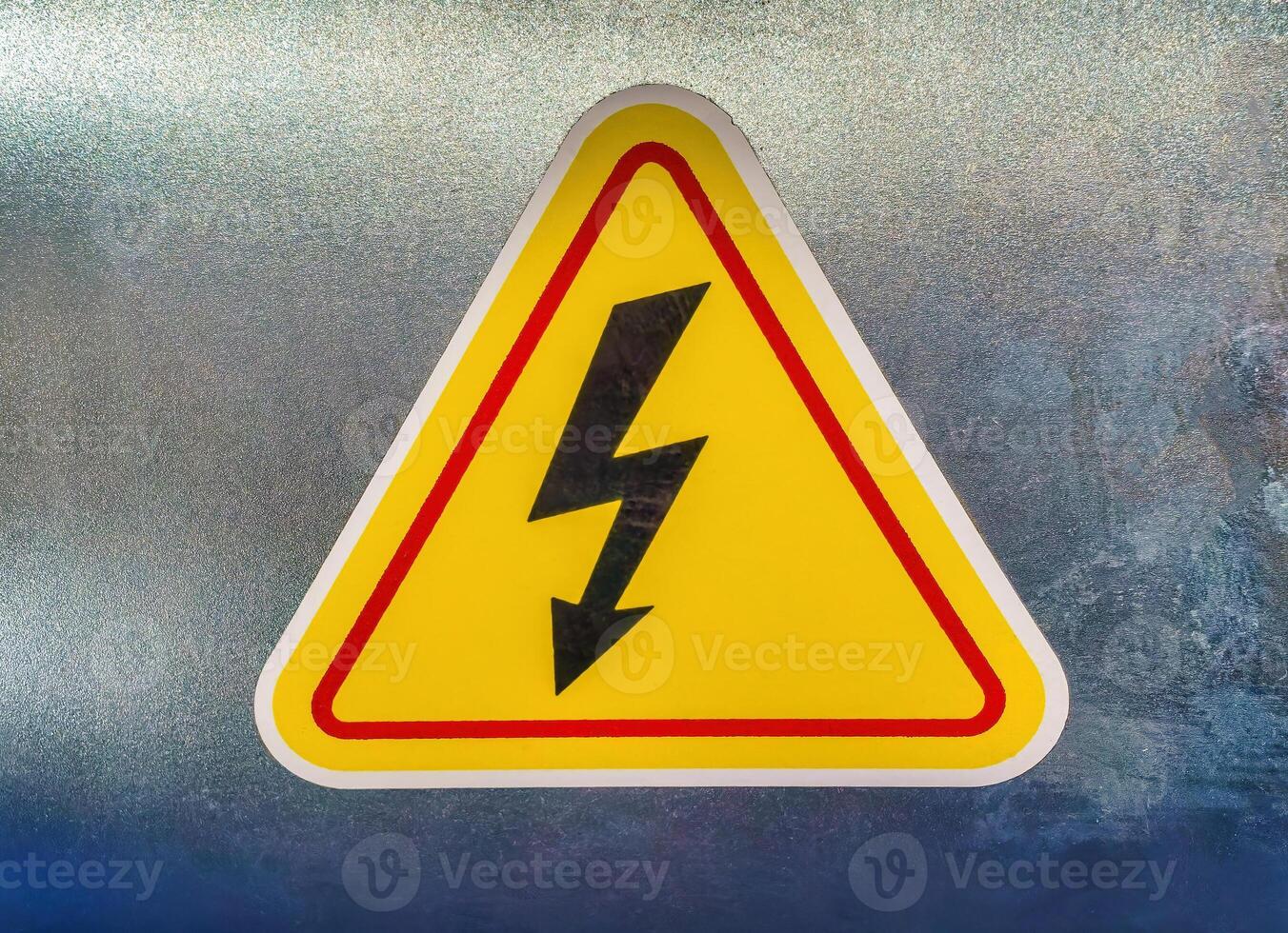 High voltage sign in the form of a lightning bolt on a yellow triangle. photo