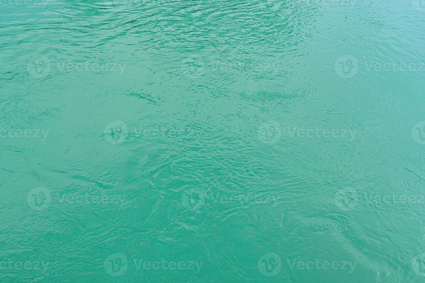 The texture of the waves of turquoise color of fast-flowing water in the river. photo