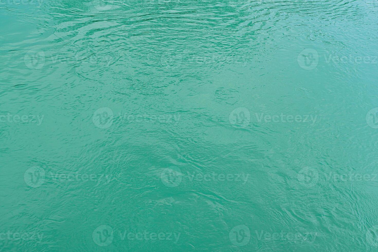 The texture of the waves of turquoise color of fast-flowing water in the river. photo