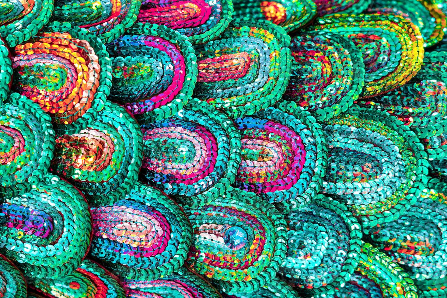 Beautiful multi-colored sequins shimmering in the light in the form of a peacock tail. Abstract background. photo