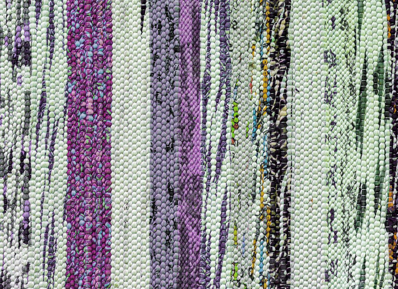 Texture of a multi-colored wicker floor carpet close-up. Abstract background. photo