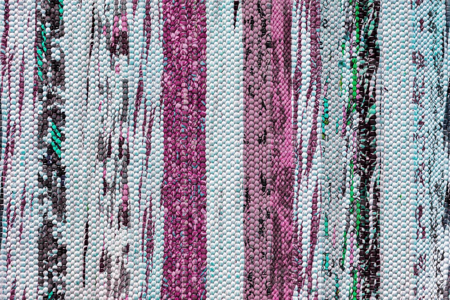 Texture of a multi-colored wicker floor carpet close-up. Abstract background. photo