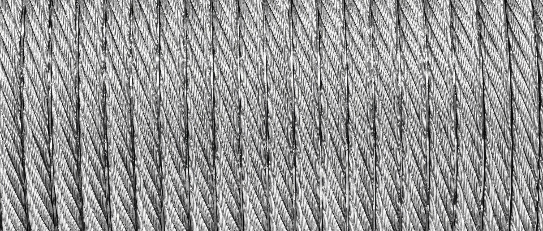 The texture of a new stainless steel cable wrapped in a spool. Abstract background. photo