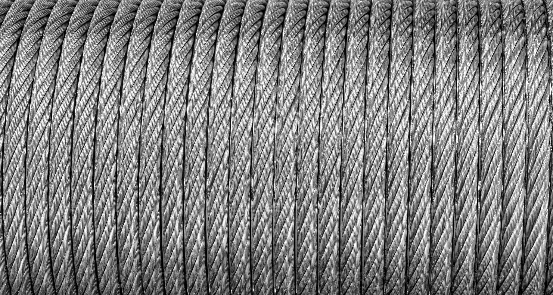The texture of a new stainless steel cable wrapped in a spool. Abstract background. photo