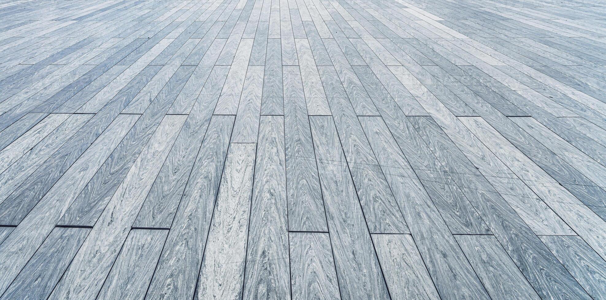 The texture of a gray plank wooden scratched floor with perspective. photo