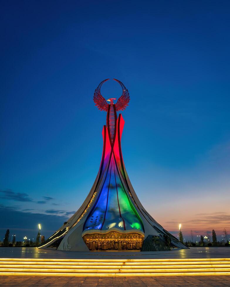UZBEKISTAN, TASHKENT - JANUARY 4, 2023 Illuminated monument of independence in the form of a stele with a Humo bird in the New Uzbekistan park at night. photo