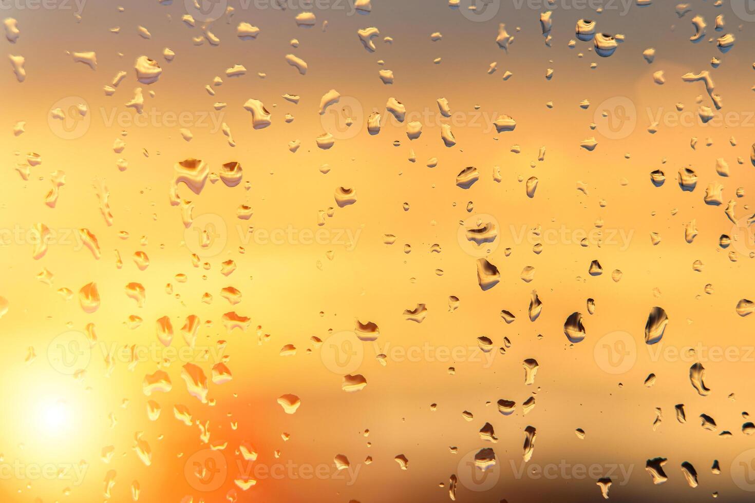 Raindrops on a window with a sunset sky in the background. photo