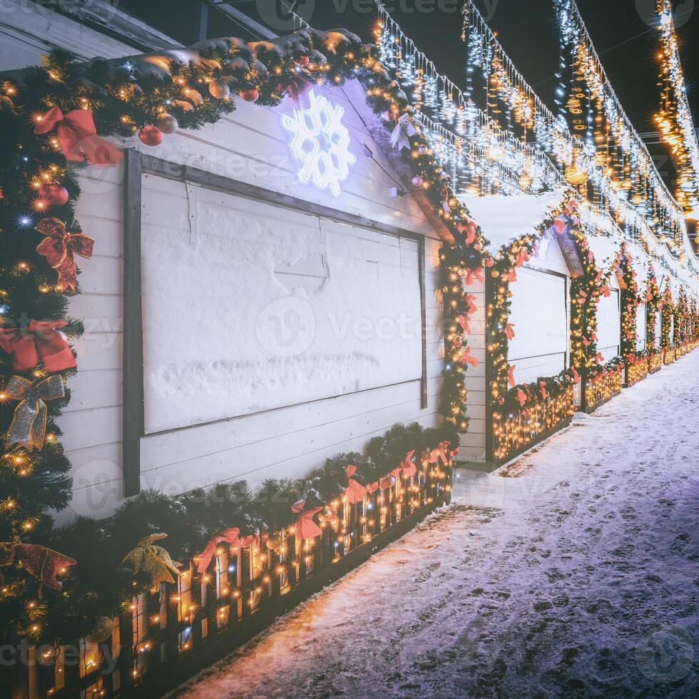 Christmas or New Year's market in a Europe with houses decorated with toy balls and garlands at night. Vintage film aesthetic. photo