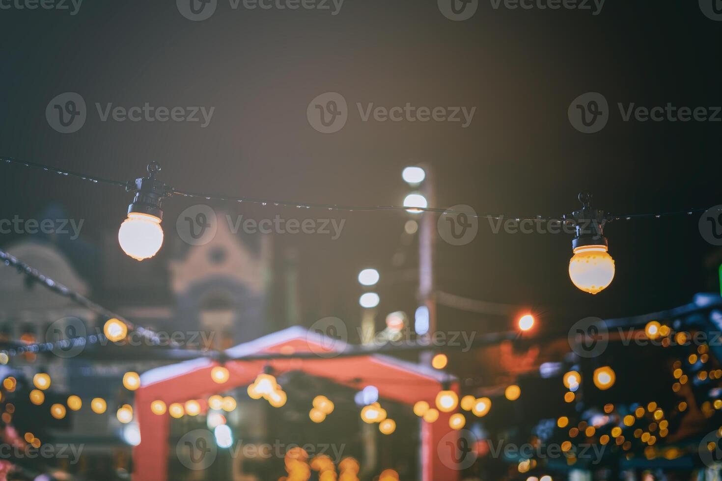 Navidad o nuevo años mercado en un Europa con casas decorado con juguete pelotas y guirnaldas a noche. Clásico película estético. foto