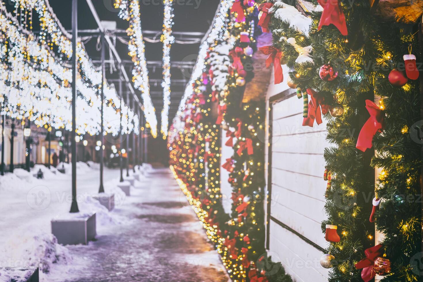 Christmas or New Year's market in a Europe with houses decorated with toy balls and garlands at night. Vintage film aesthetic. photo