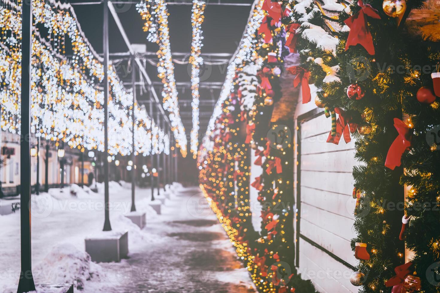 Christmas or New Year's market in a Europe with houses decorated with toy balls and garlands at night. Vintage film aesthetic. photo