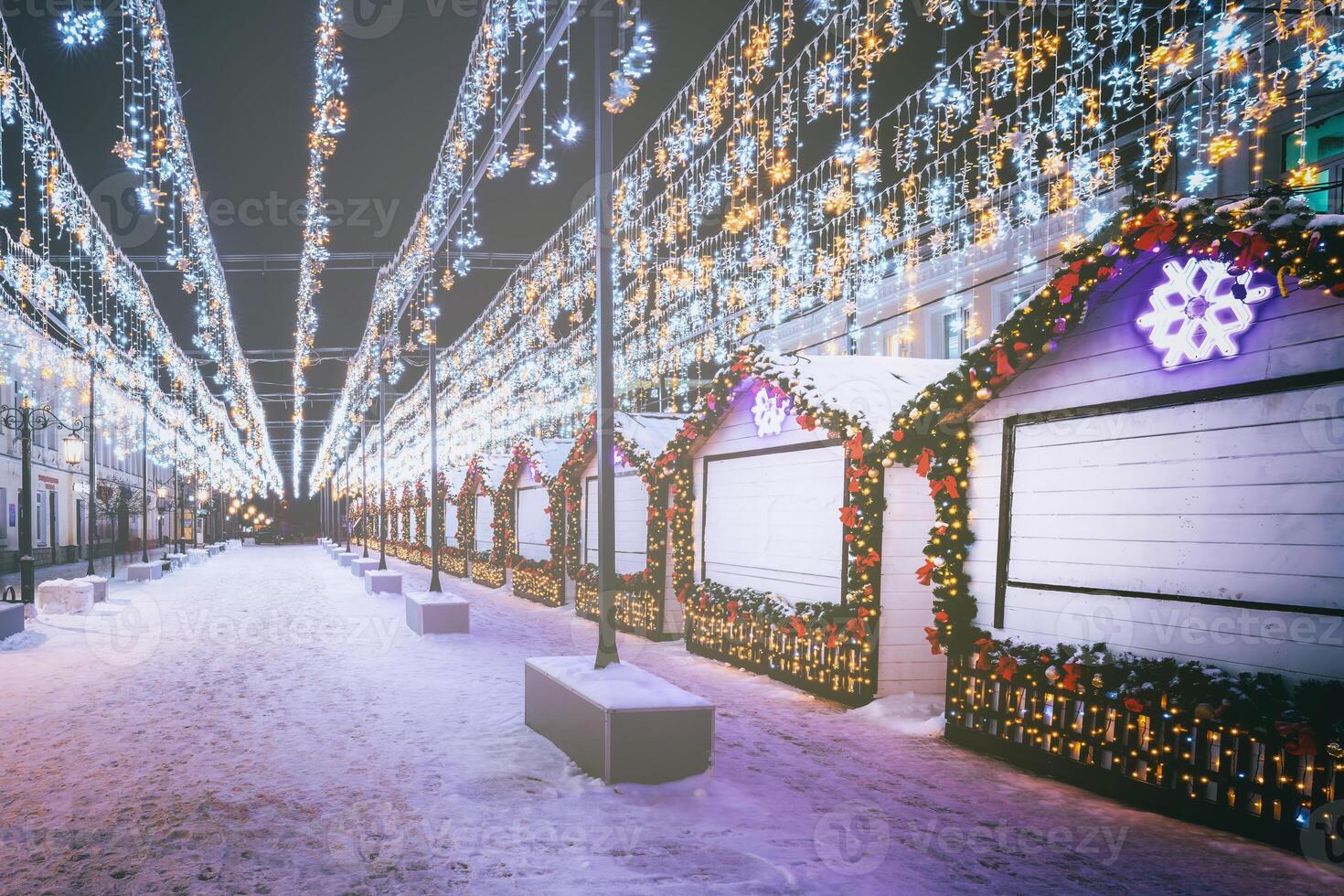 Christmas or New Year's market in a Europe with houses decorated with toy balls and garlands at night. Vintage film aesthetic. photo