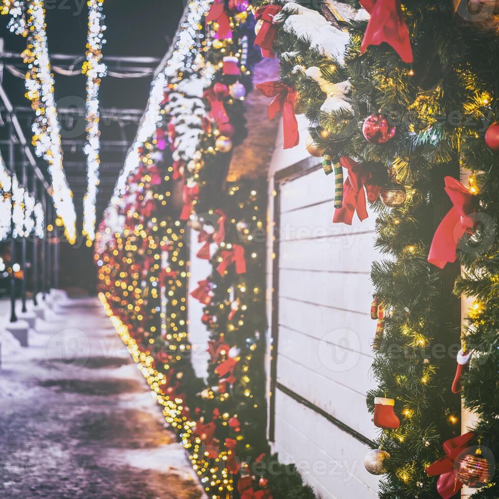 Christmas or New Year's market in a Europe with houses decorated with toy balls and garlands at night. Vintage film aesthetic. photo