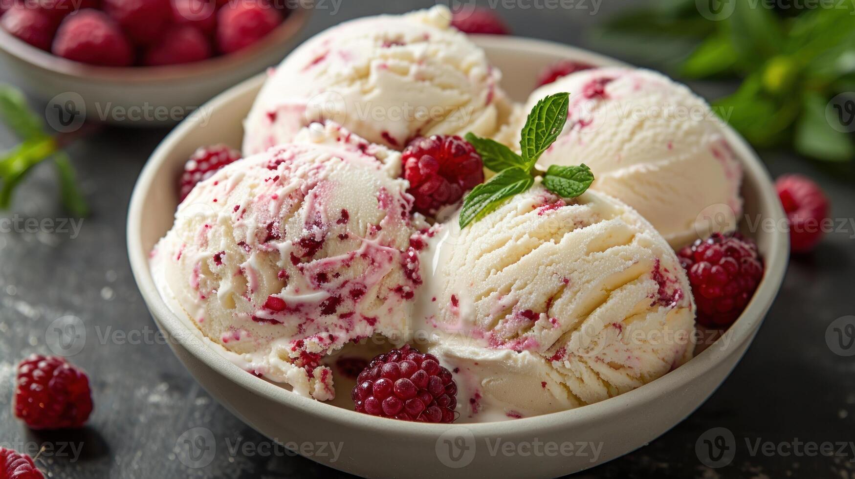 A bowl filled with vanilla ice cream topped with fresh raspberries photo