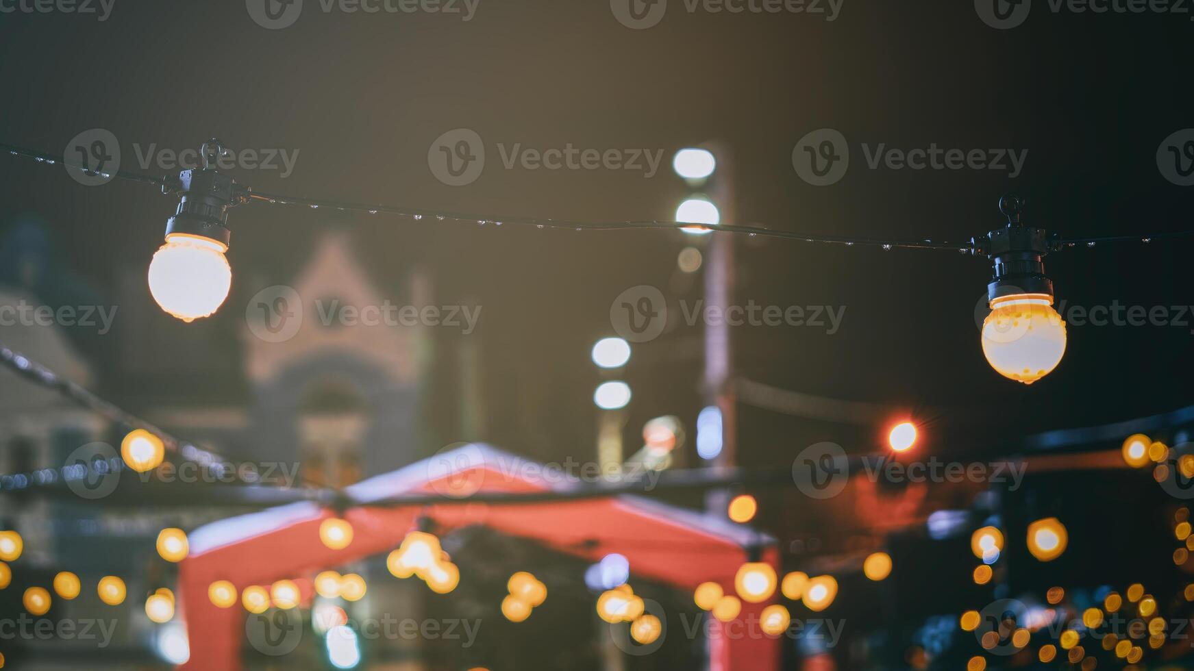 Christmas or New Year's market in a Europe with houses decorated with toy balls and garlands at night. Vintage film aesthetic. photo