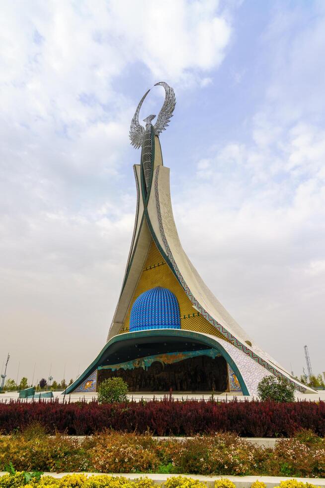 Tahkent, Uzbekistan - October 17, 2023 Monument of Independence in the form of a stele with a Humo bird on a cloudy day in the New Uzbekistan park. photo