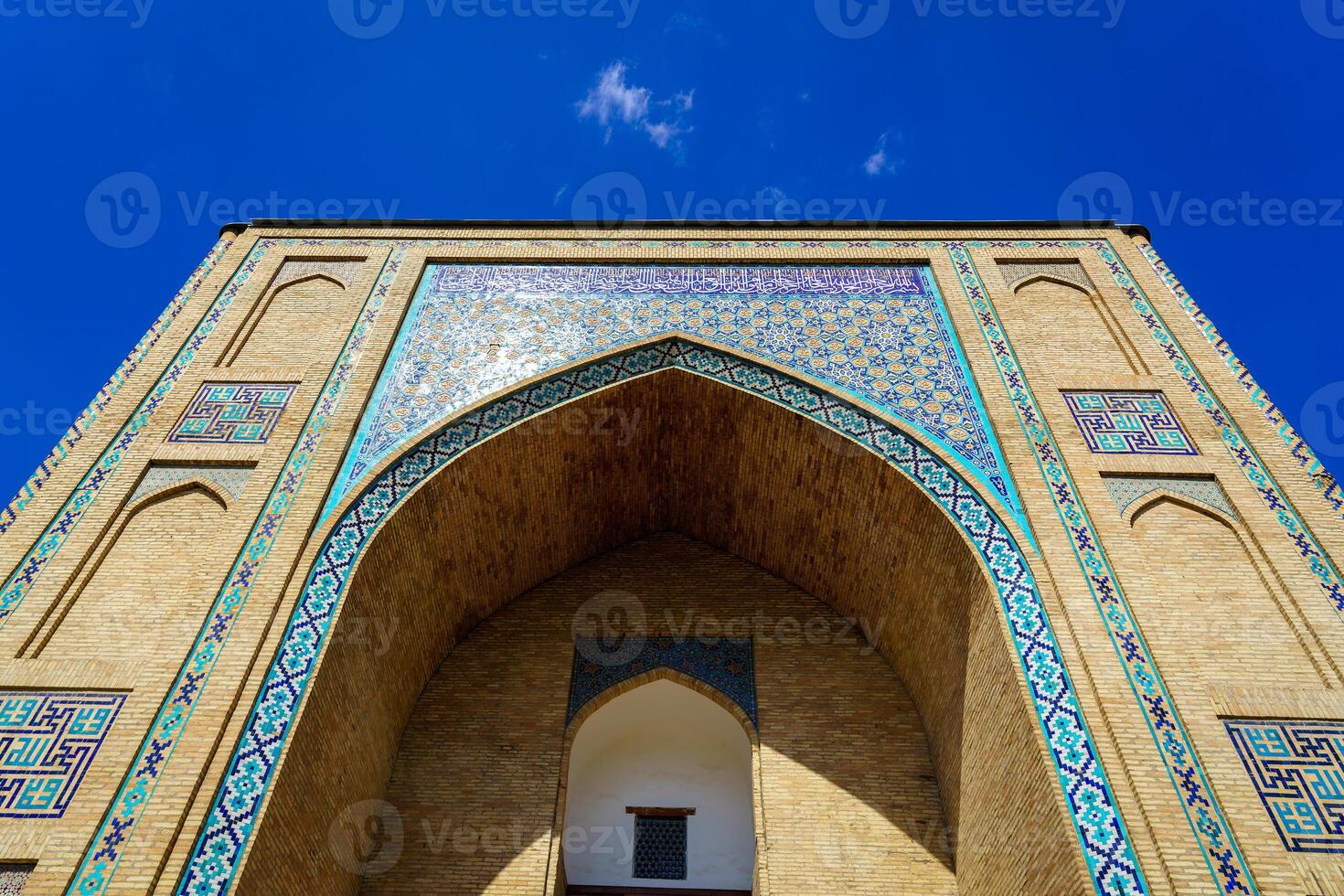 Entrance to mosques made of brick against a blue cloudless sky. photo