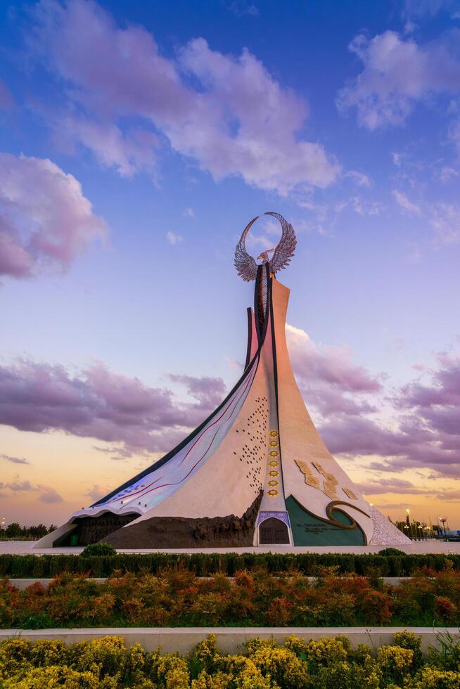 Uzbekistan, Tashkent - October 4, 2023 Monument of Independence in the form of a stele with a Humo bird on a twilight with cliody sky in the New Uzbekistan park. photo