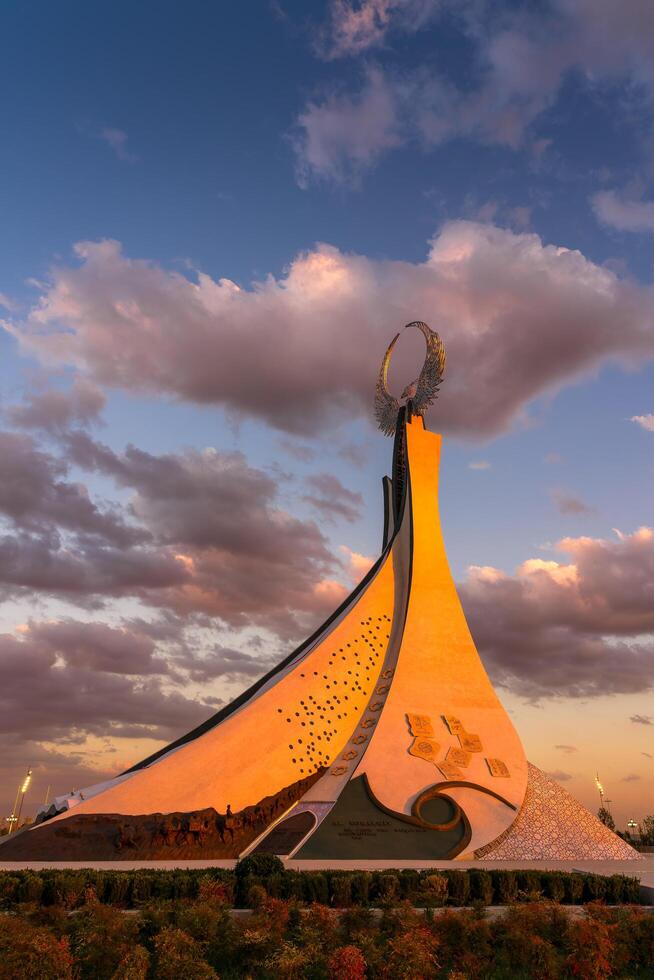 Uzbekistan, Tashkent - October 4, 2023 Monument of Independence in the form of a stele with a Humo bird on a twilight with cliody sky in the New Uzbekistan park. photo