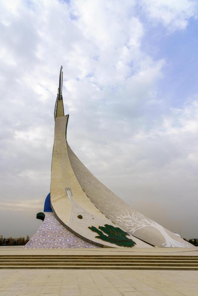 Tahkent, Uzbekistan - October 17, 2023 Monument of Independence in the form of a stele with a Humo bird on a cloudy day in the New Uzbekistan park. photo