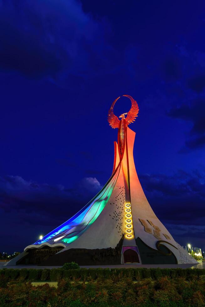Uzbekistan, Tashkent - October 4, 2023 Illuminated monument of independence in the form of a stele with a Humo bird in the New Uzbekistan park at nighttime in autumn. photo