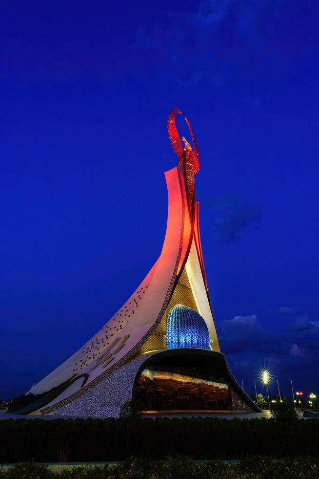 Uzbekistan, Tashkent - October 4, 2023 Illuminated monument of independence in the form of a stele with a Humo bird in the New Uzbekistan park at nighttime in autumn. photo