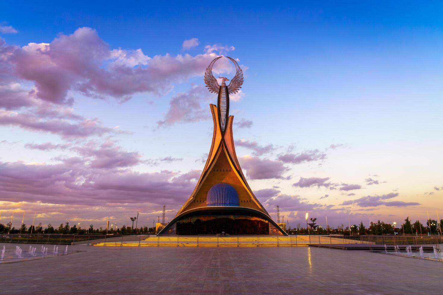 Uzbekistan, Tashkent - October 4, 2023 Monument of Independence in the form of a stele with a Humo bird on a twilight with cliody sky in the New Uzbekistan park. photo