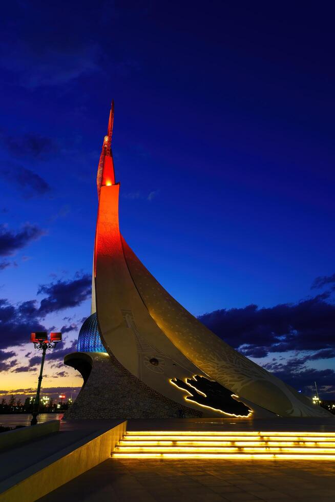 Uzbekistan, Tashkent - October 4, 2023 Illuminated monument of independence in the form of a stele with a Humo bird in the New Uzbekistan park at nighttime in autumn. photo